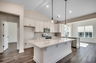 bright white kitchen with large island and black pendant lighting 