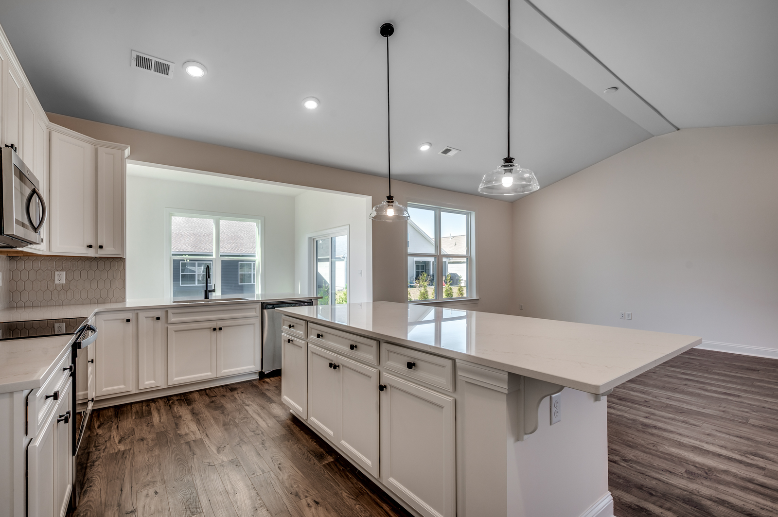 open-concept kitchen with large island, white quartz countertops and black hardware