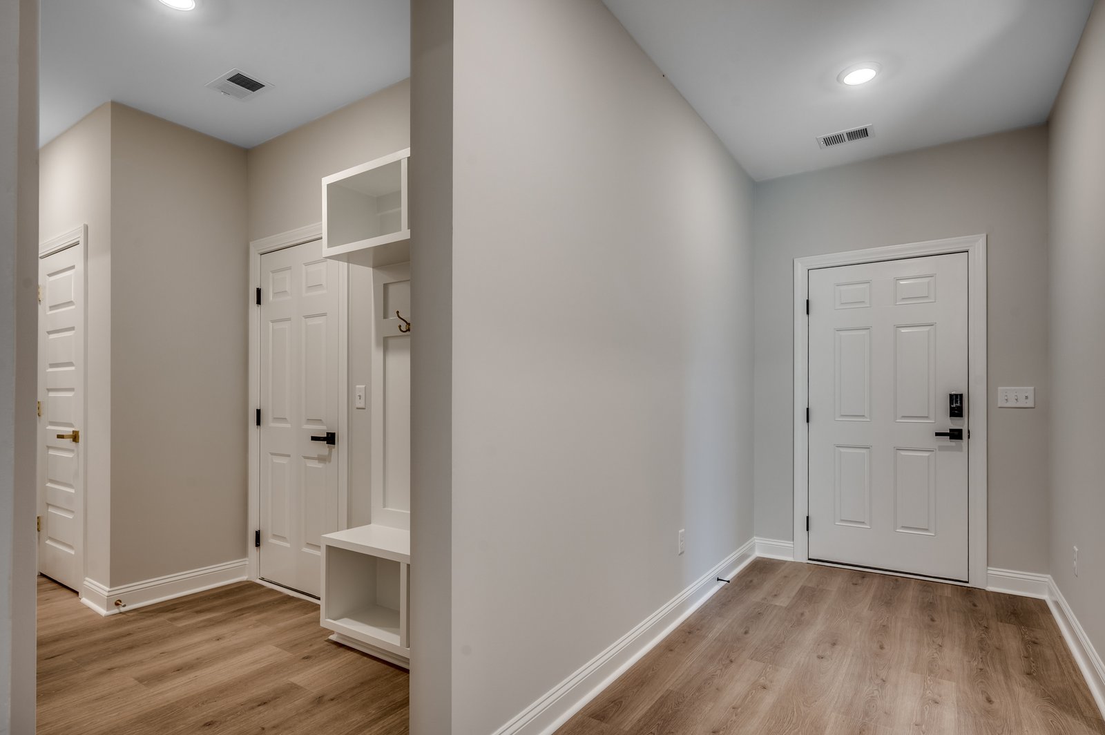 hardwood flooring and gray walls fill the space of this cozy entryway