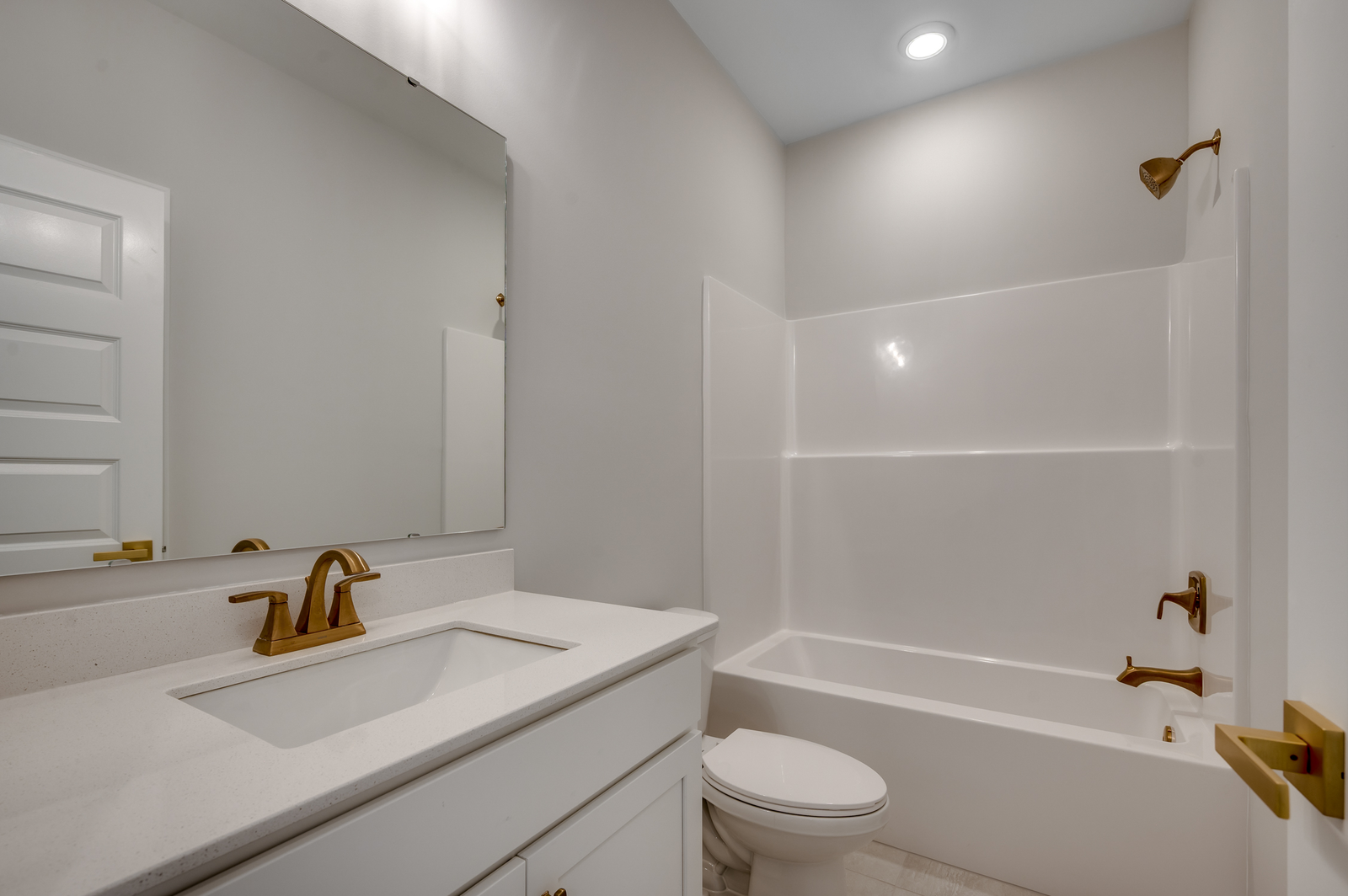 bright white single sink vanity with gold hardware and fixtures