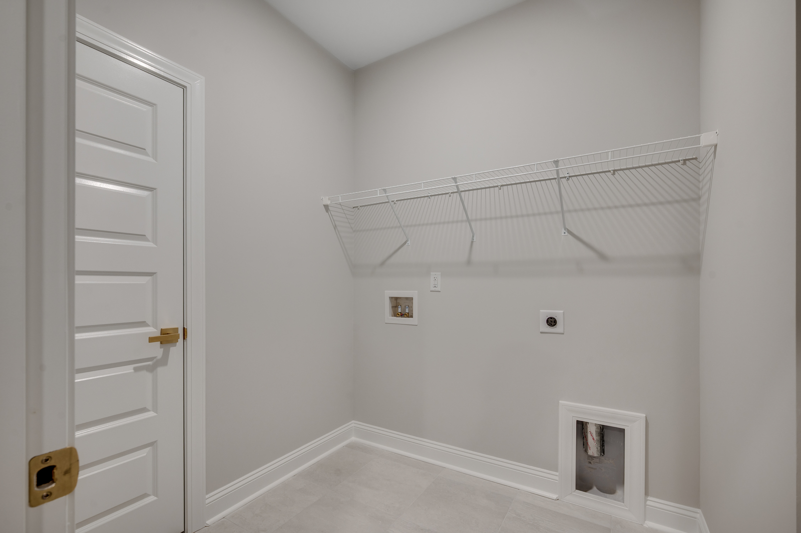 large room with light gray walls, white wire shelving and tiled flooring throughout