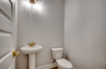 cozy space with light gray walls, single sink vanity and gold hardware 