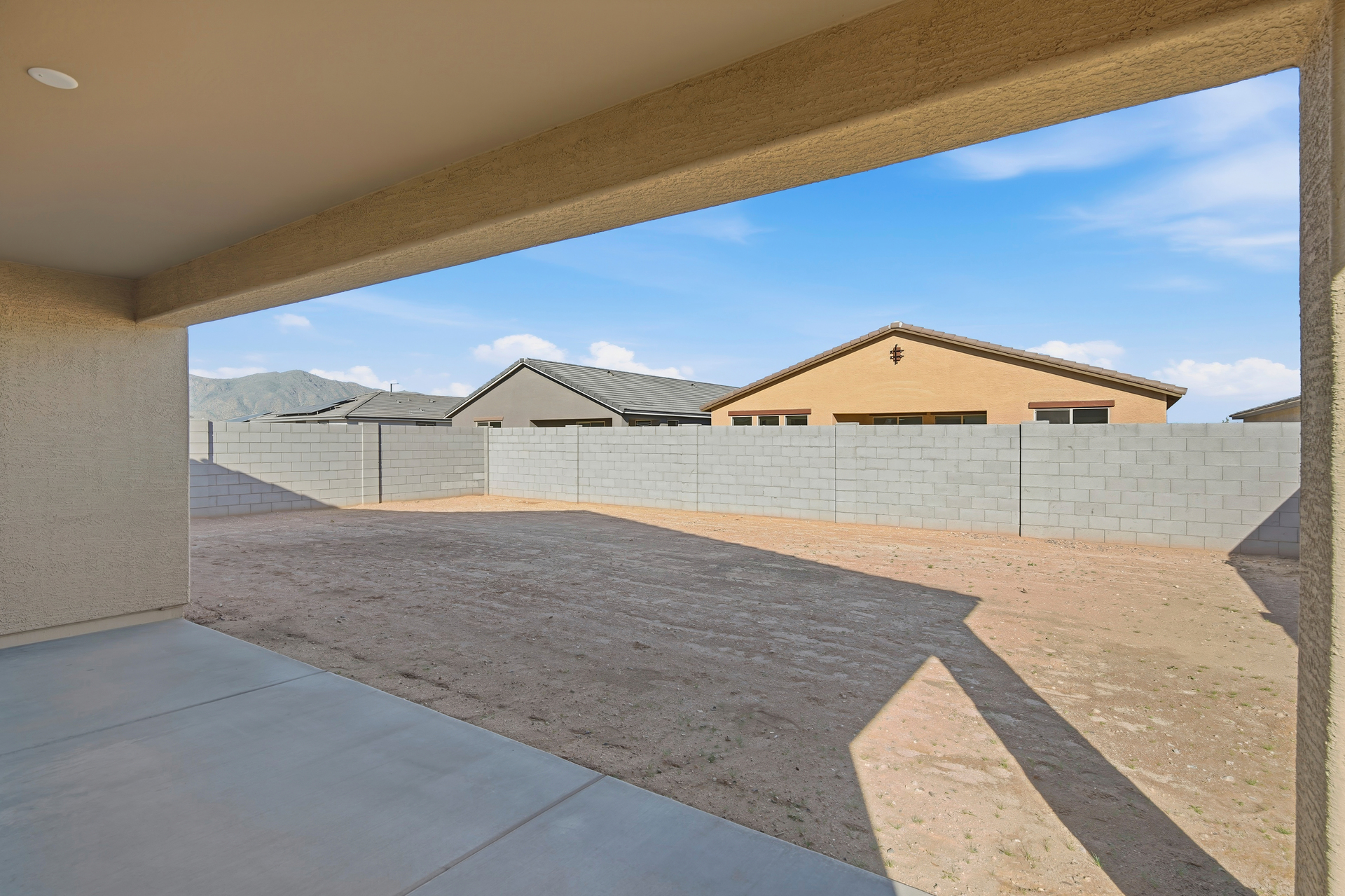 spacious backyard with a concrete block wall