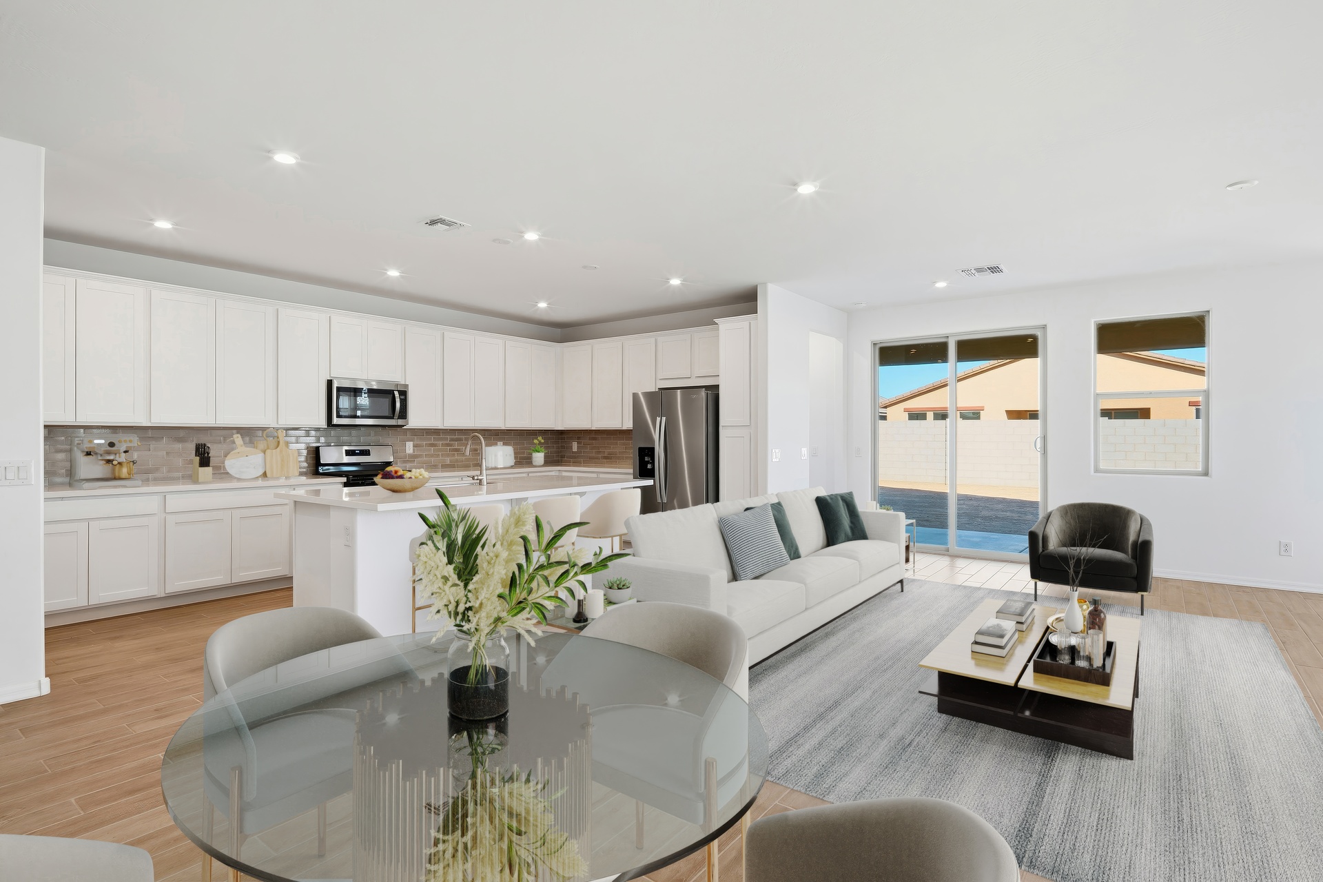 open-concept space with large couch and a glass dining table