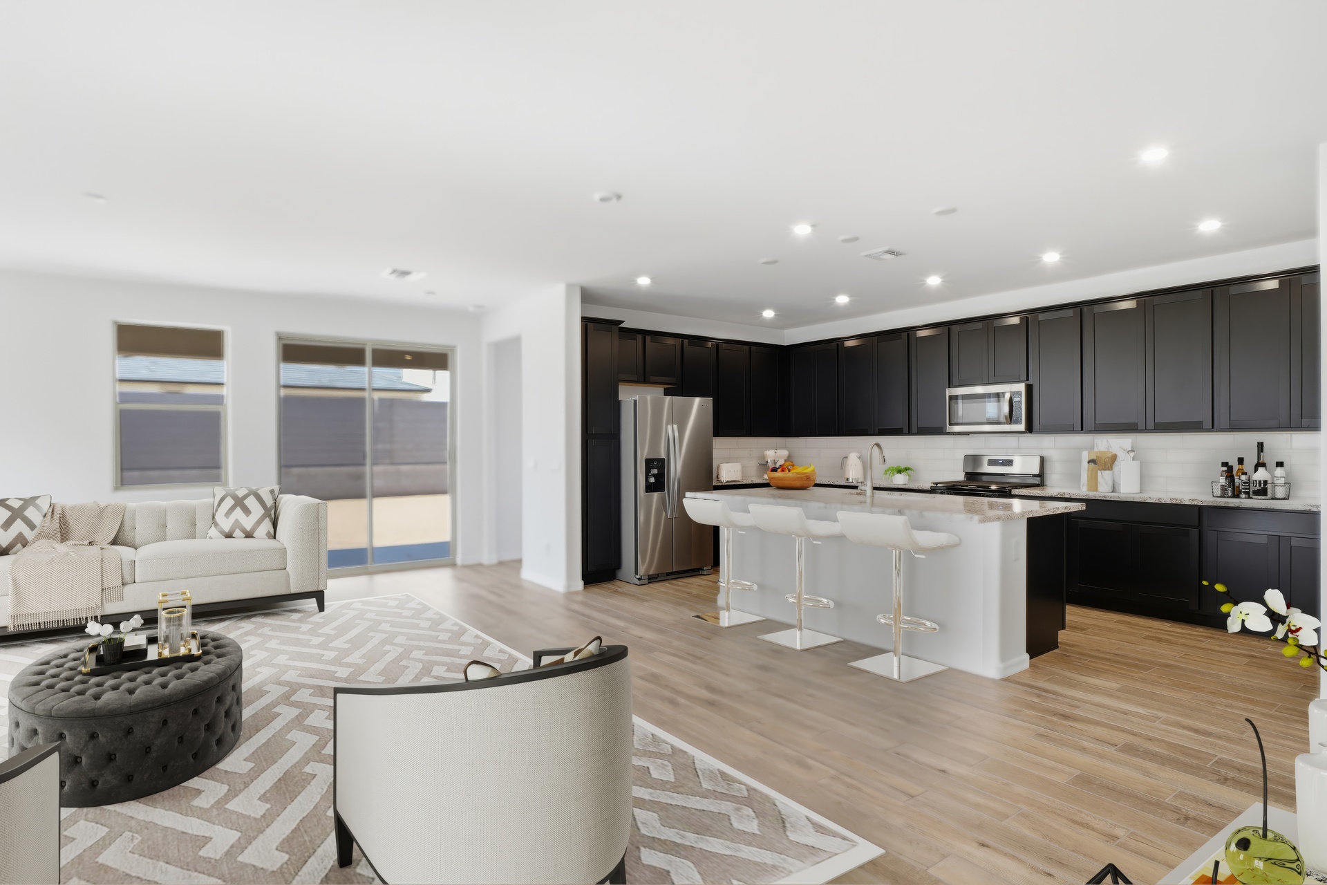 open-concept space with wood-like flooring, white accent chairs, and beige rug