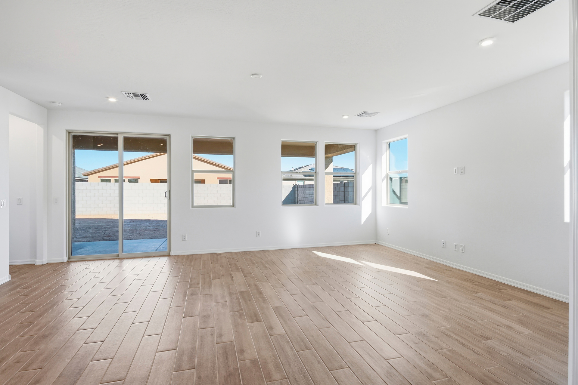 open-concept space with wood-like tile flooring and access to the backyard patio