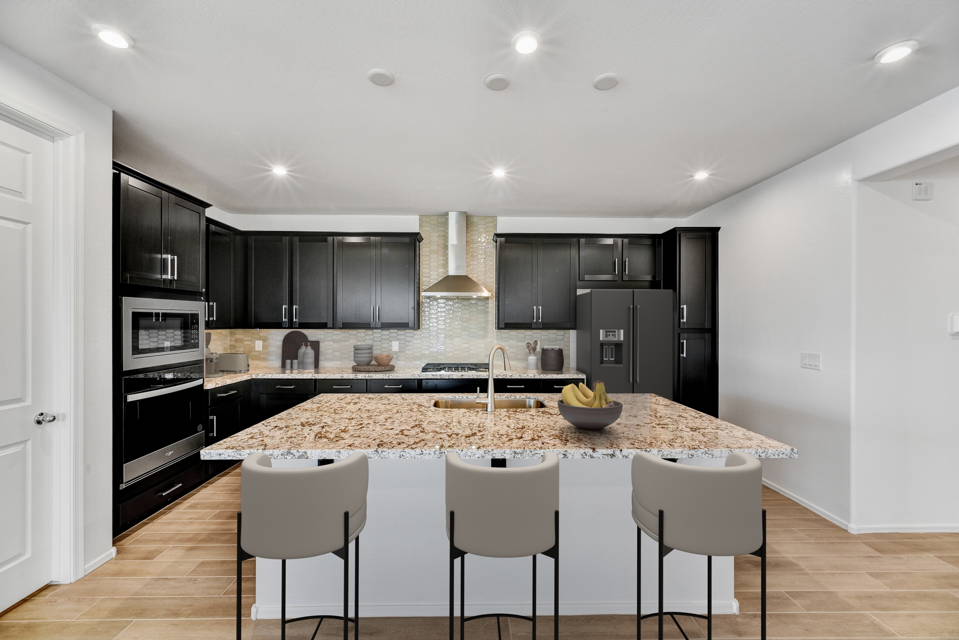 kitchen with wood-like flooring, white barstools, and stainless-steel appliances