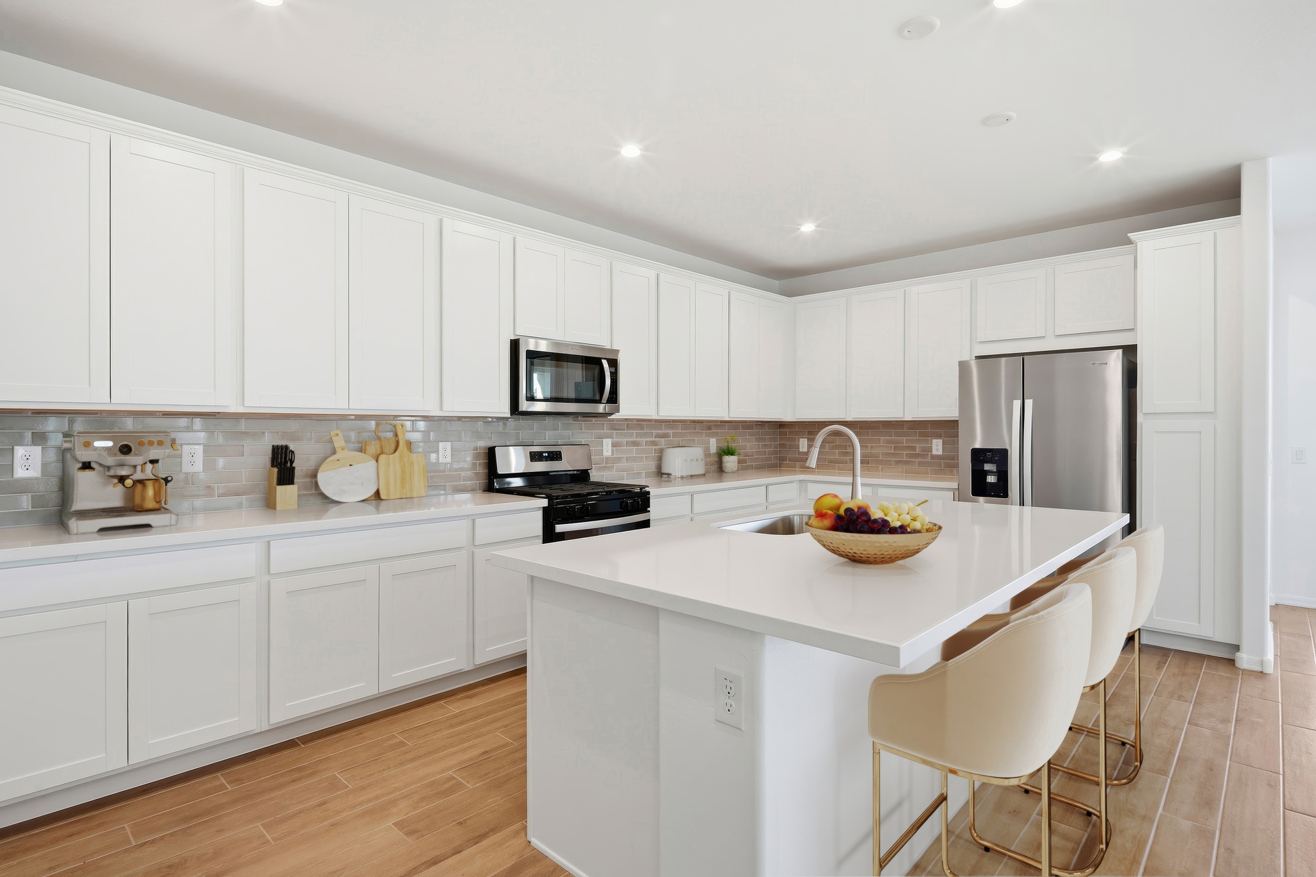 kitchen with white barstools, quartz countertops, and stainless-steel appliances