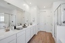 spacious bathroom with a double sink and brushed nickel faucets
