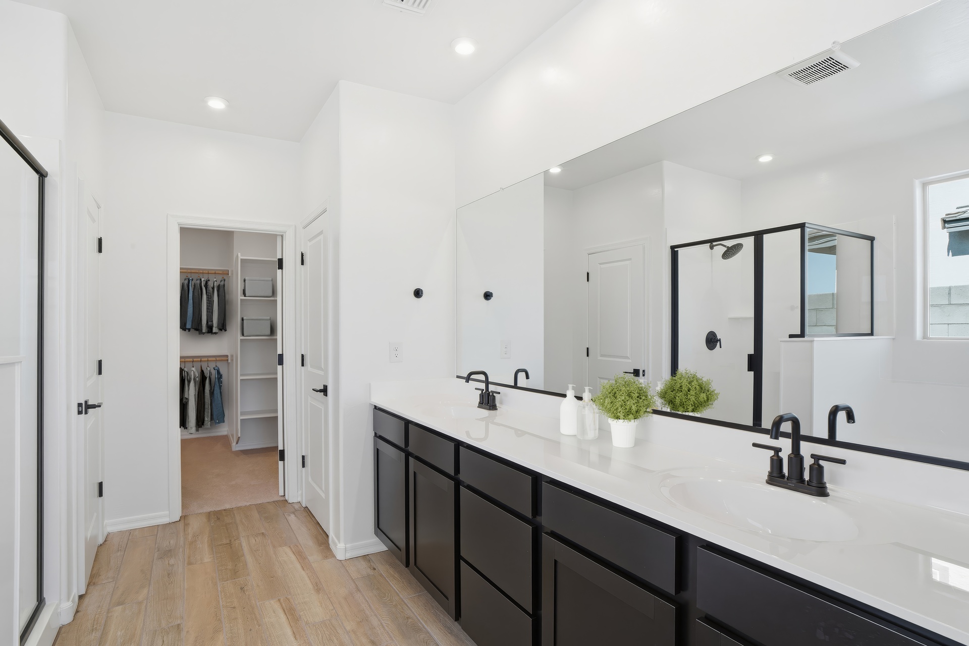 spacious bathroom with black cabinets, black faucets, and a white countertop