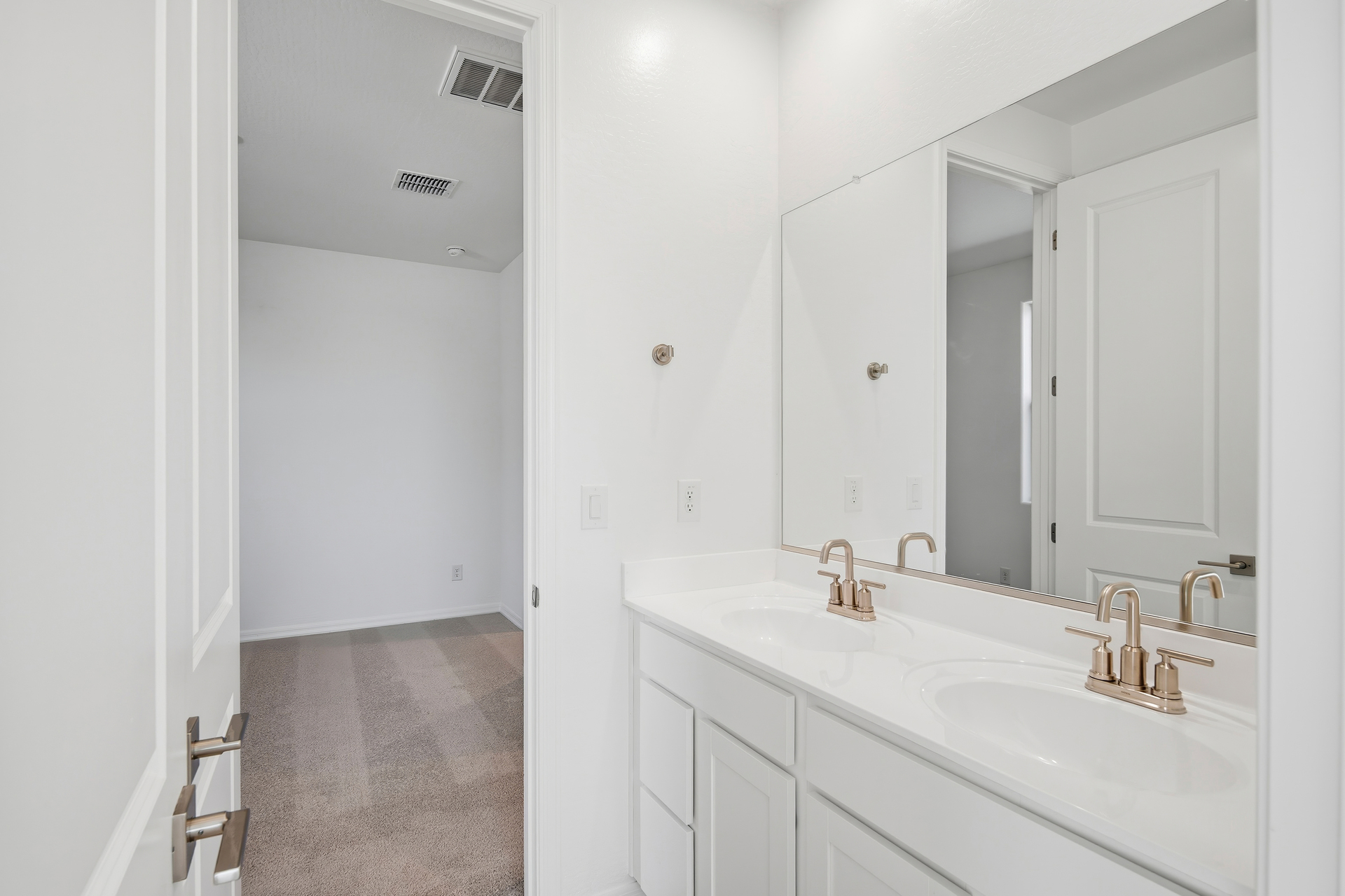 Jack and Jill bathroom with brushed nickel faucets and white countertops