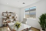 spacious at-home office with a white desk, a white office chair, and wooden shelves