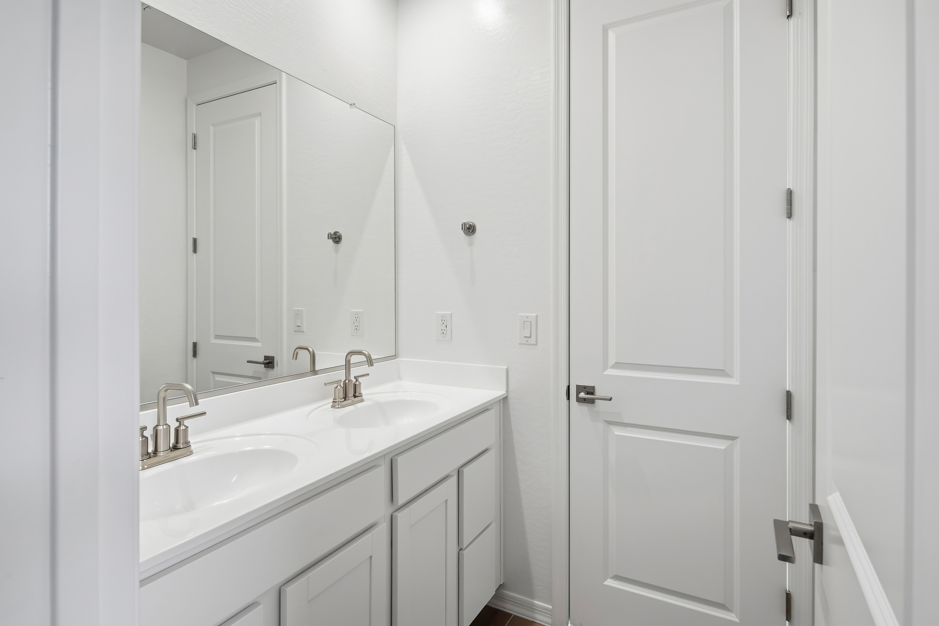 Jack and Jill bathroom with brushed nickel faucets and white countertops