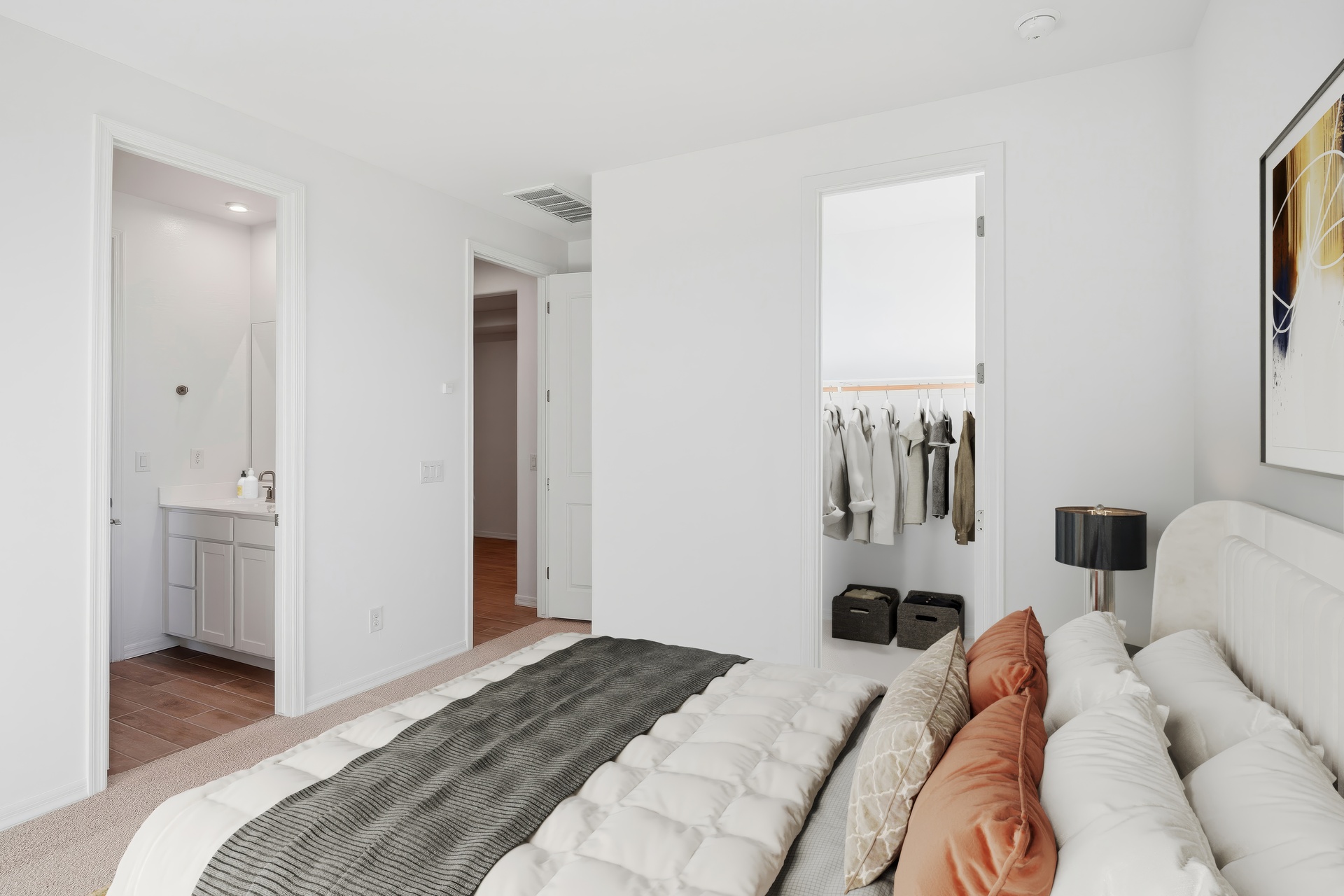 bedroom with a large bed with orange pillows and walk-in closet
