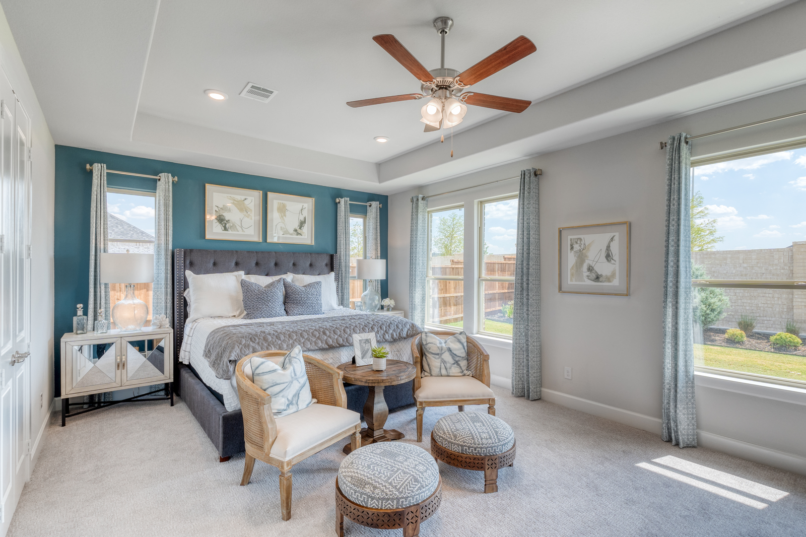 large primary bedroom with windows and carpet