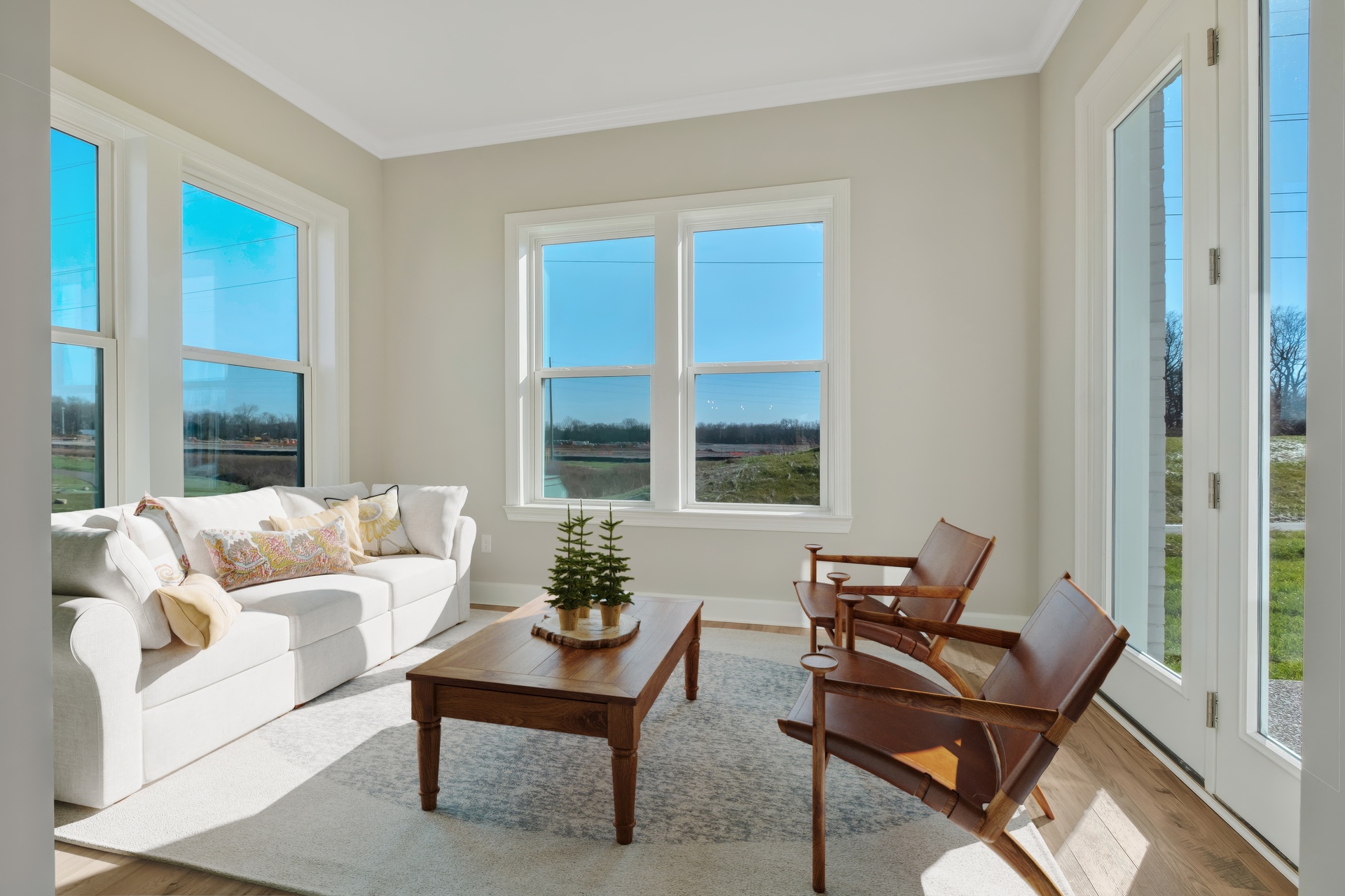 morning room with wood floors, a white sofa, accent furniture, and large windows