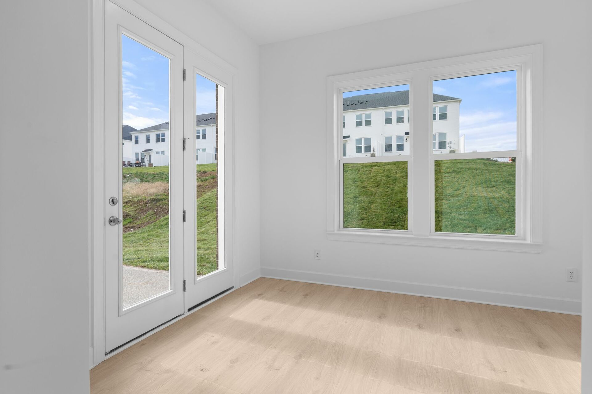 morning room with wood flooring, glass double doors, and large windows