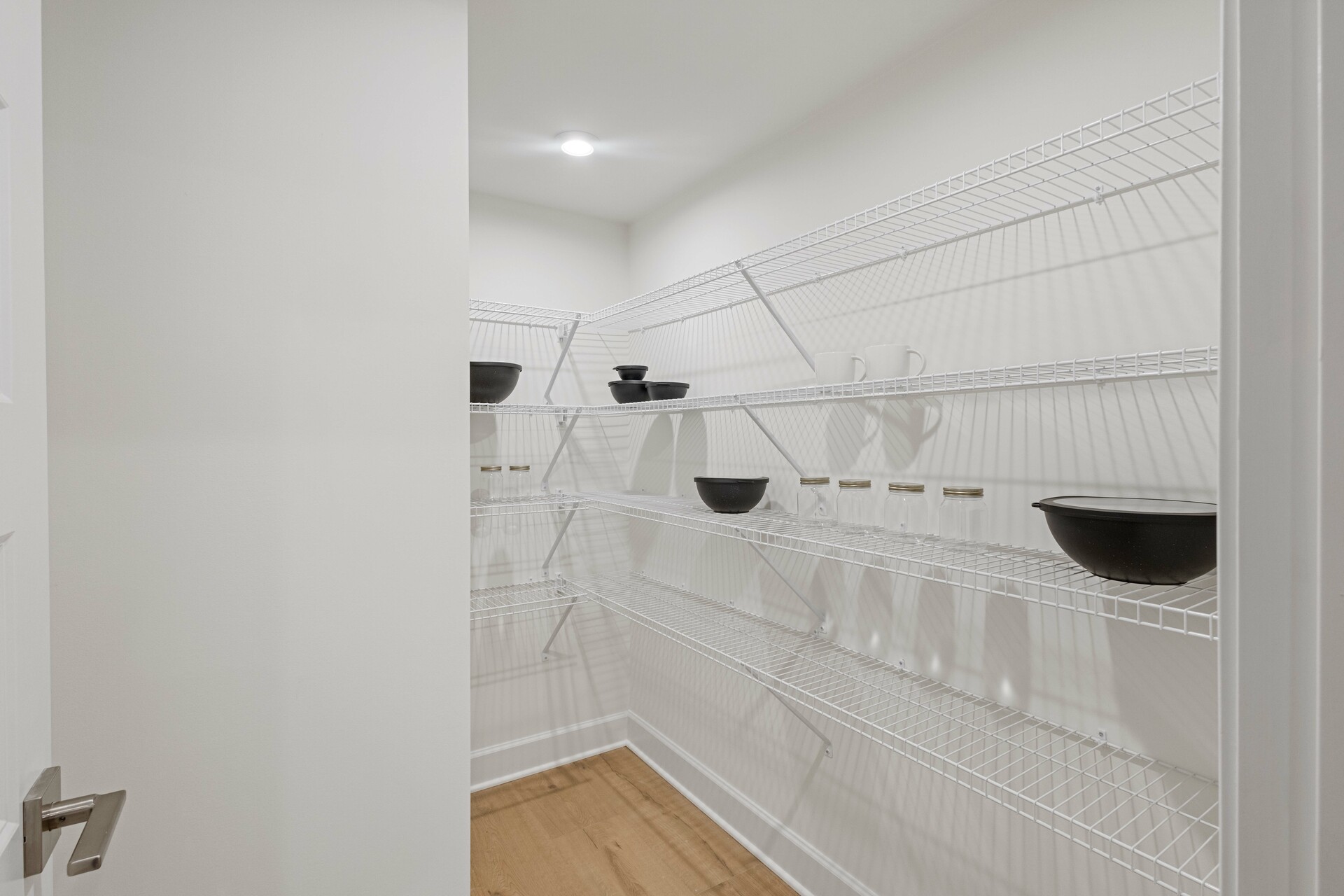 large walk-in pantry with built in wire shelves