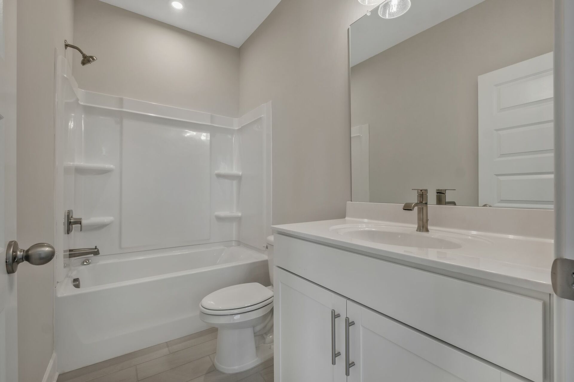 secondary bathroom with single sink vanity, white cabinets, and a shower and tub combination