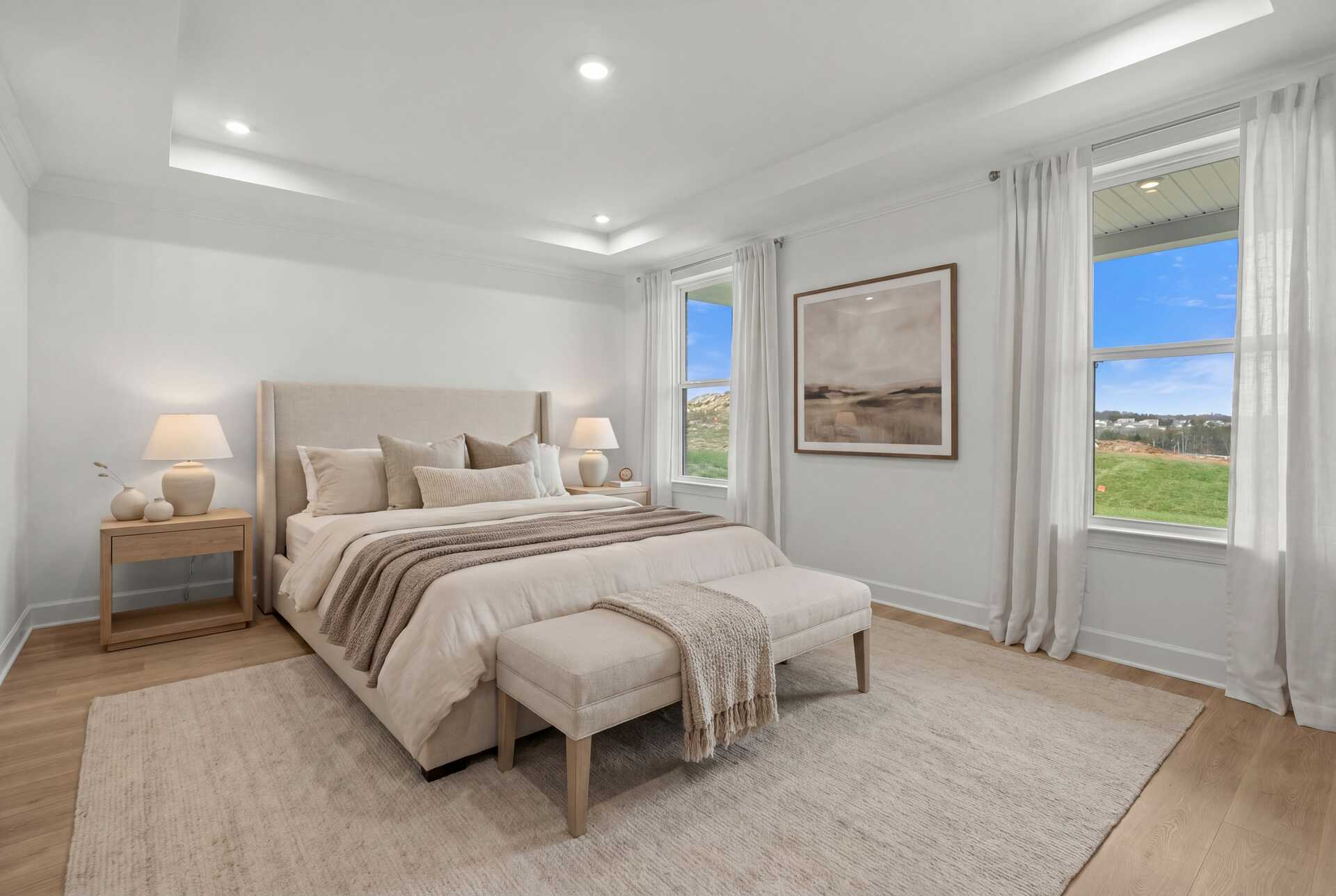 primary bedroom with wood flooring, area rug, bed, nightstands, and large windows