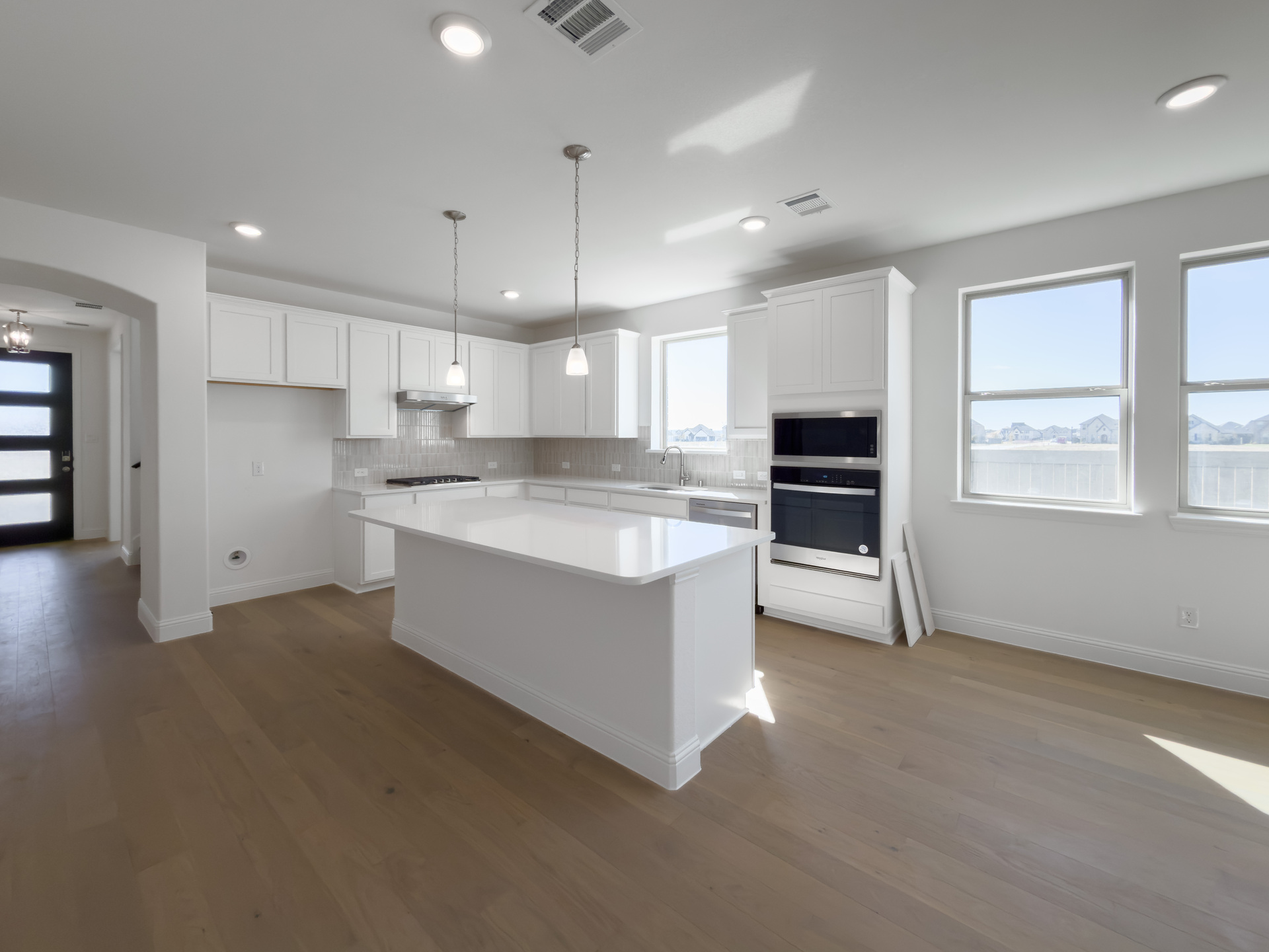 open kitchen with white cabinets and built-in appliances