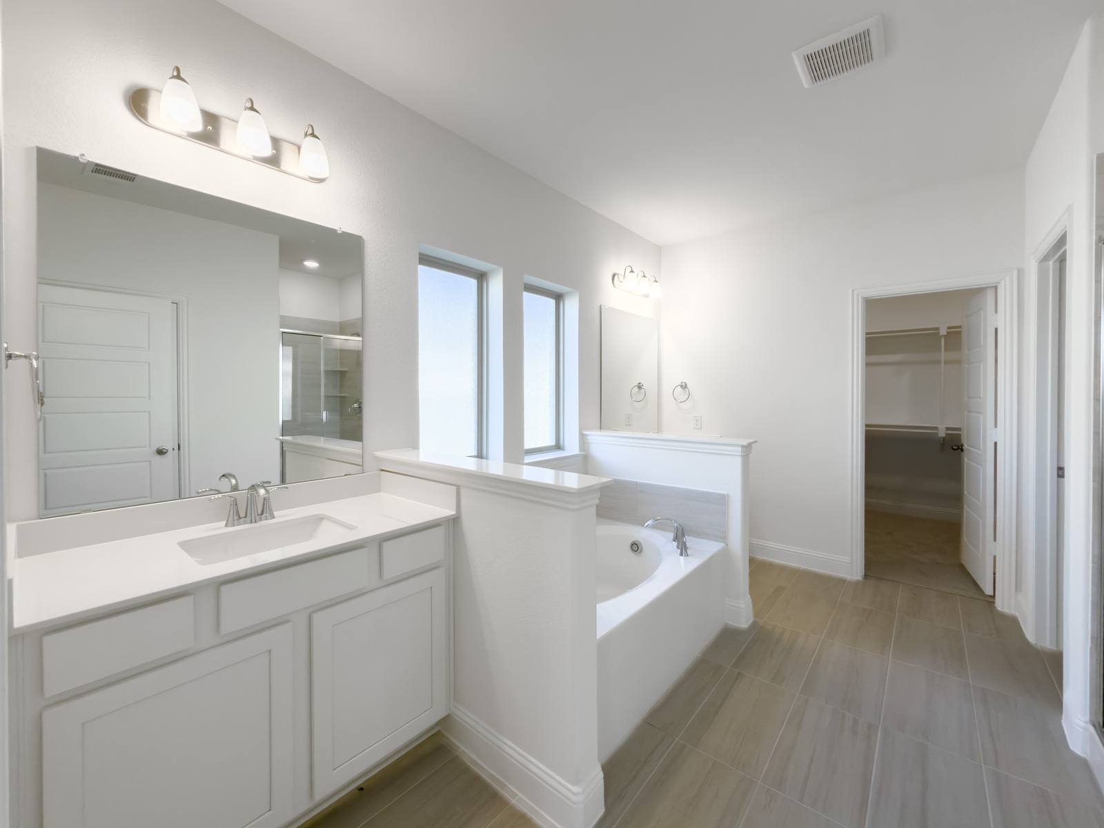 primary bathroom with double sinks and soaking tub