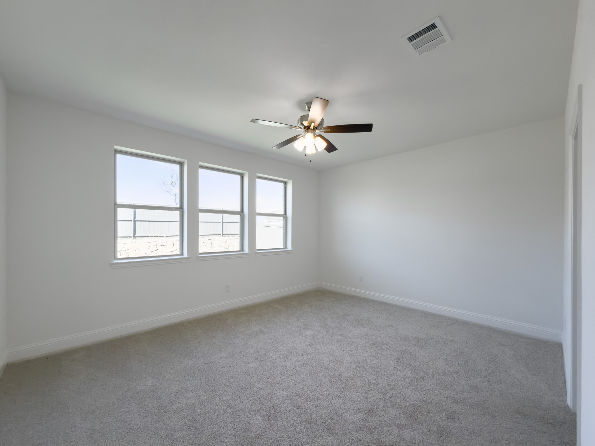 primary bedroom with carpet and windows