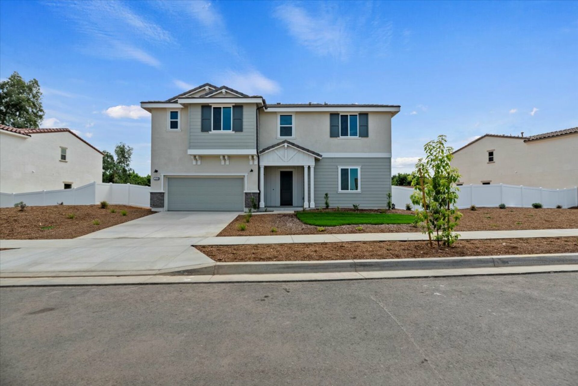exterior of two-story home with front yard landscaping and neutral paint