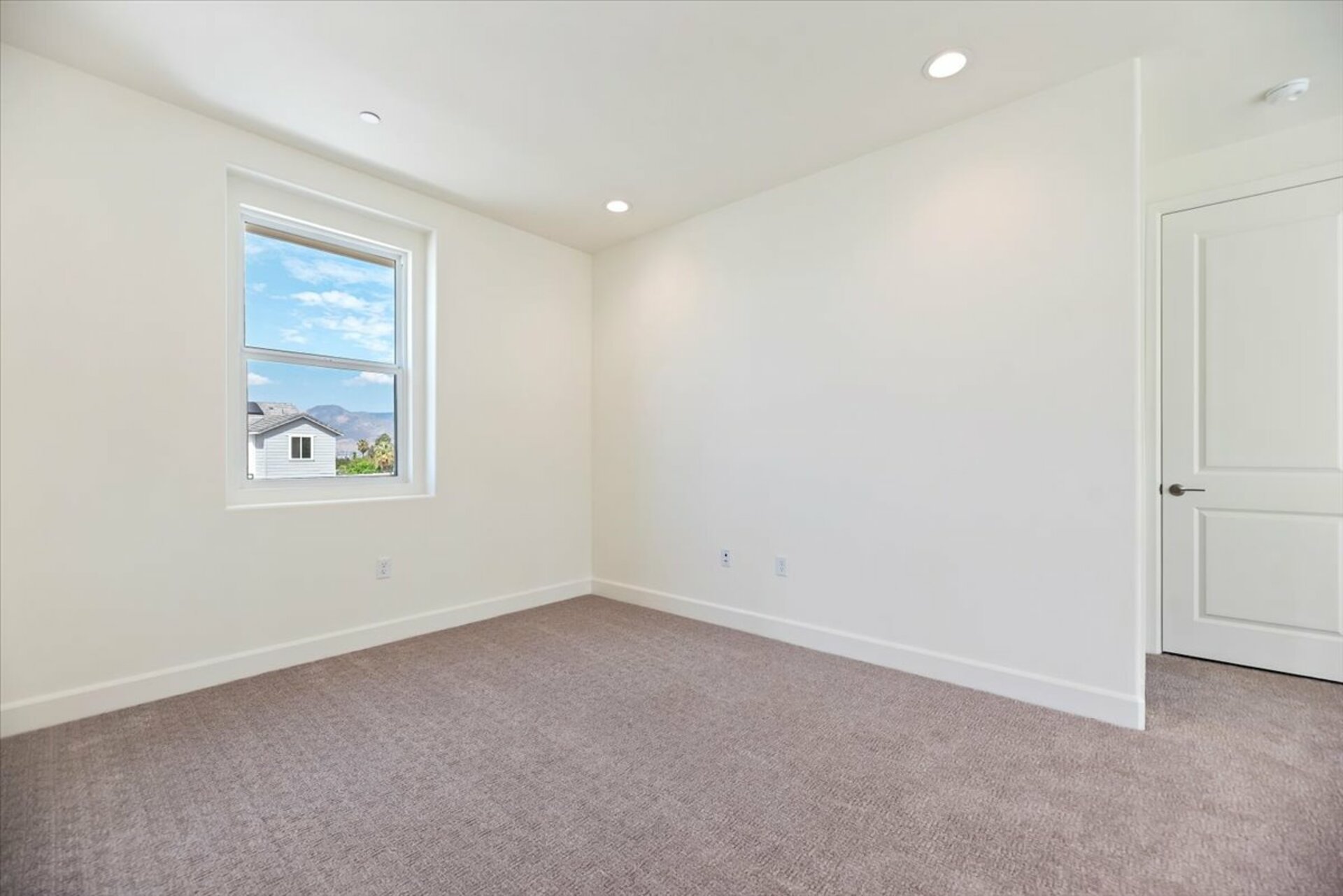 loft with neutral carpet and large window
