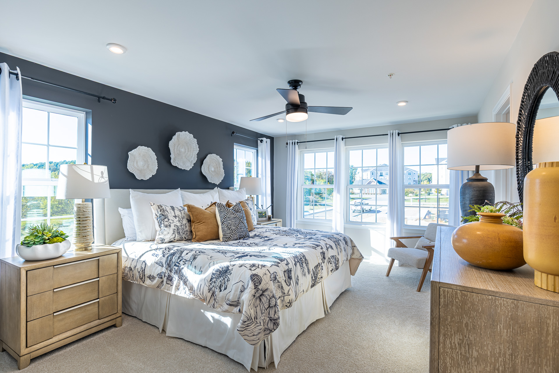 primary suite with a king sized bed and multiple large windows