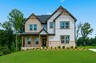 front of 2-story home on a basement with lush landscaping