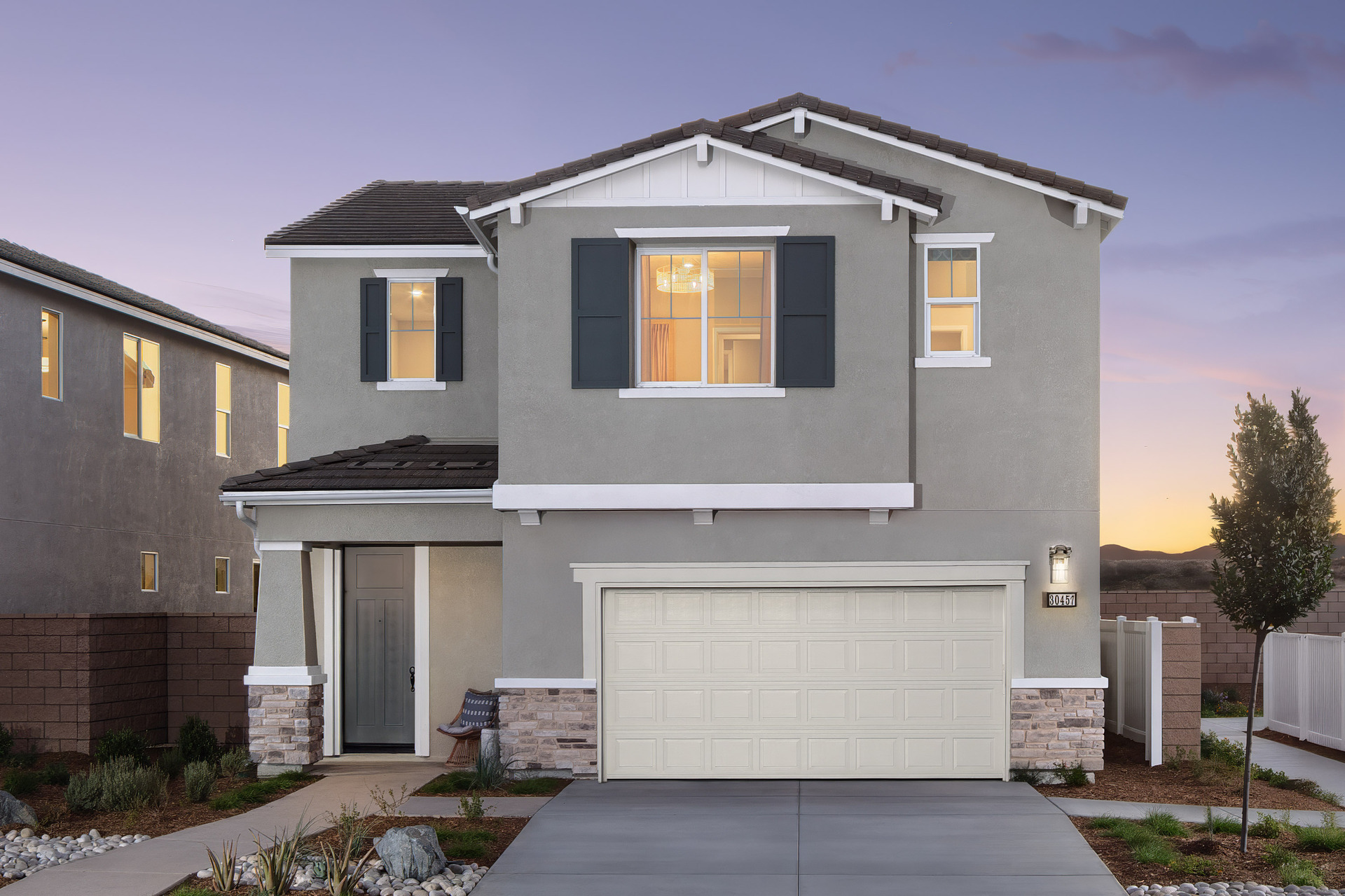 two-story exterior with a white windowless garage and gray paint
