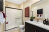 bathroom with dark cabinets and white countertops
