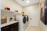 laundry room with tile floors and storage