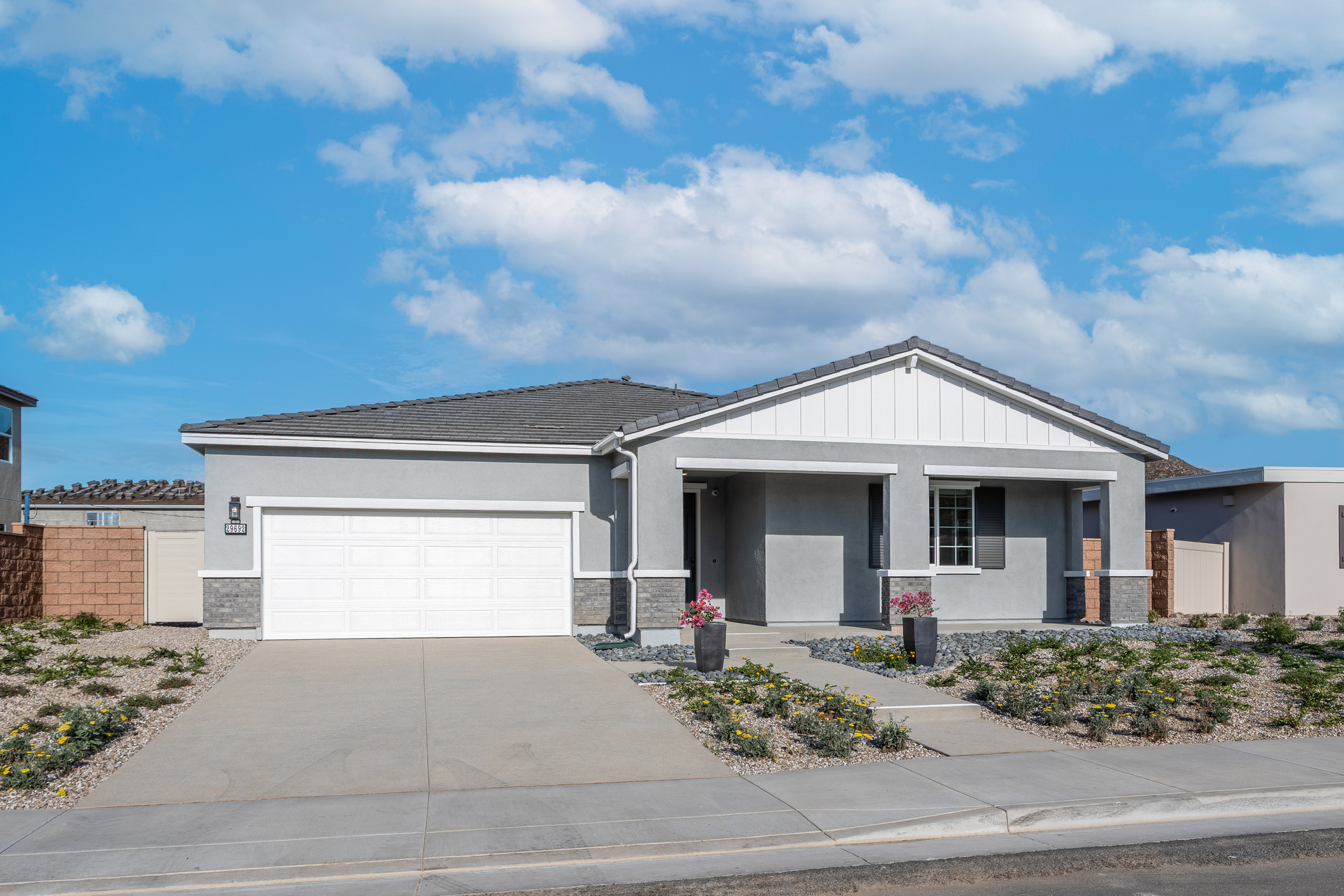 exterior of single-story home with white garage and desert landscaping