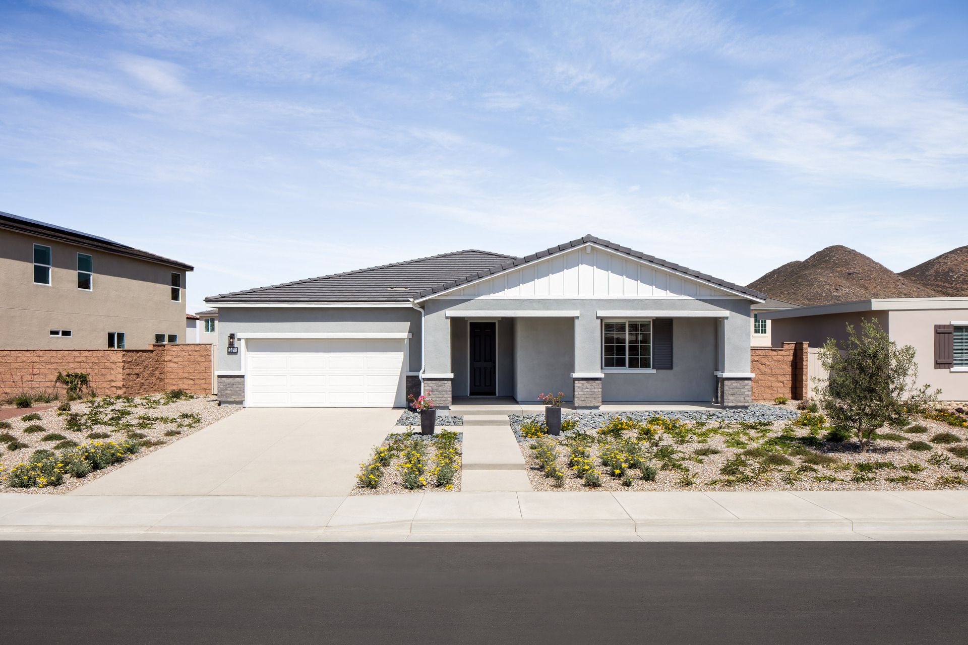 exterior of single-story home with white garage and desert landscaping