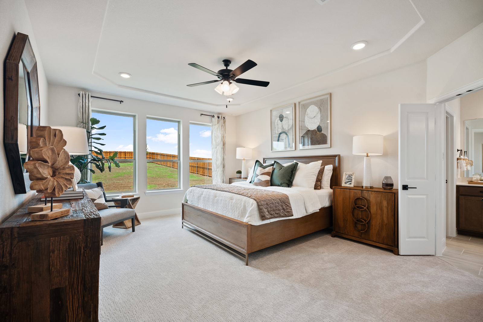 primary bedroom with carpet and large windows