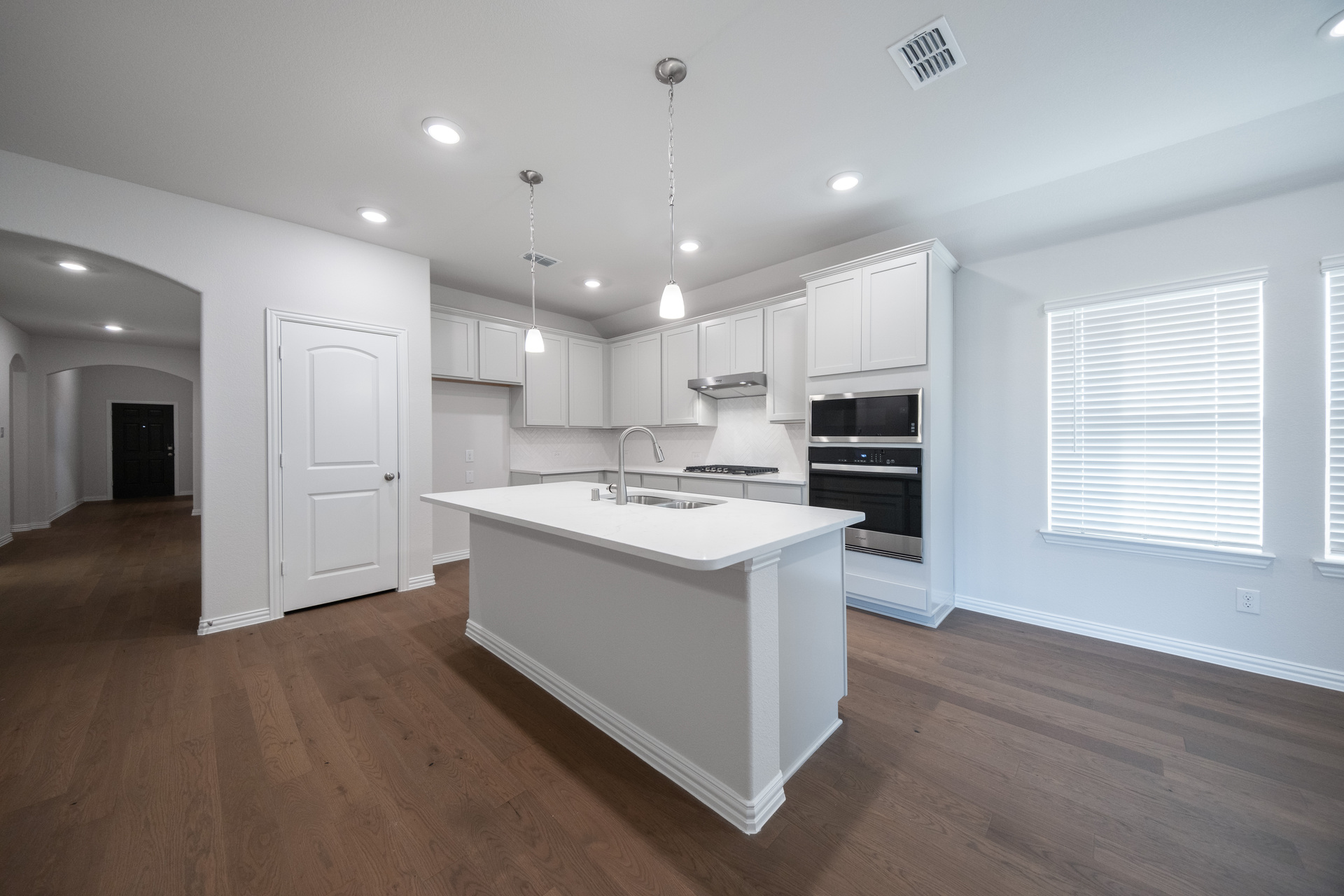 open kitchen with white cabinets and hardwood flooring