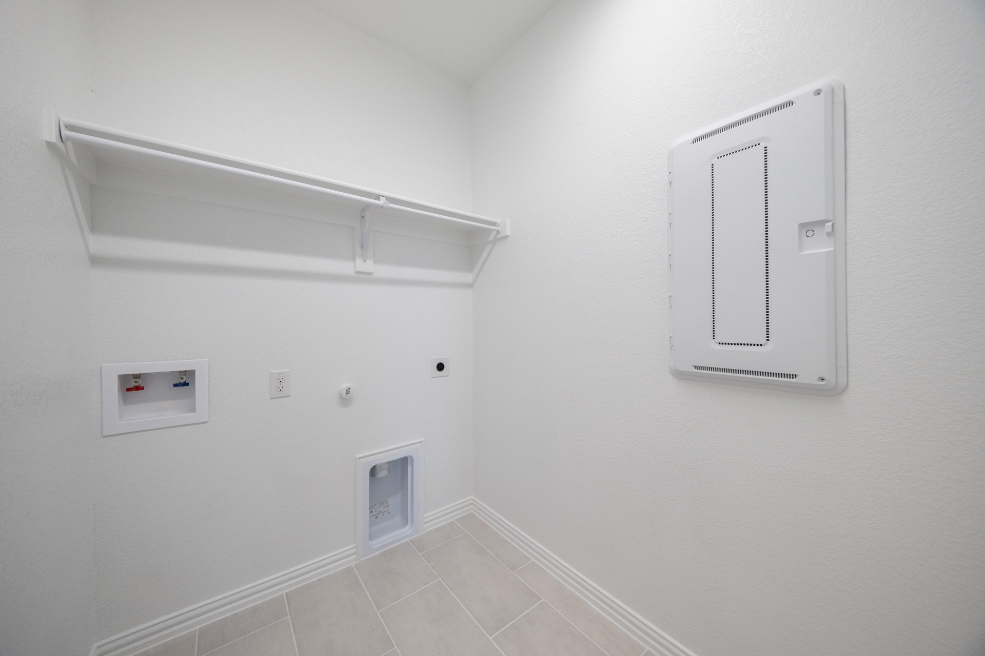 laundry room with tile flooring and storage shelf