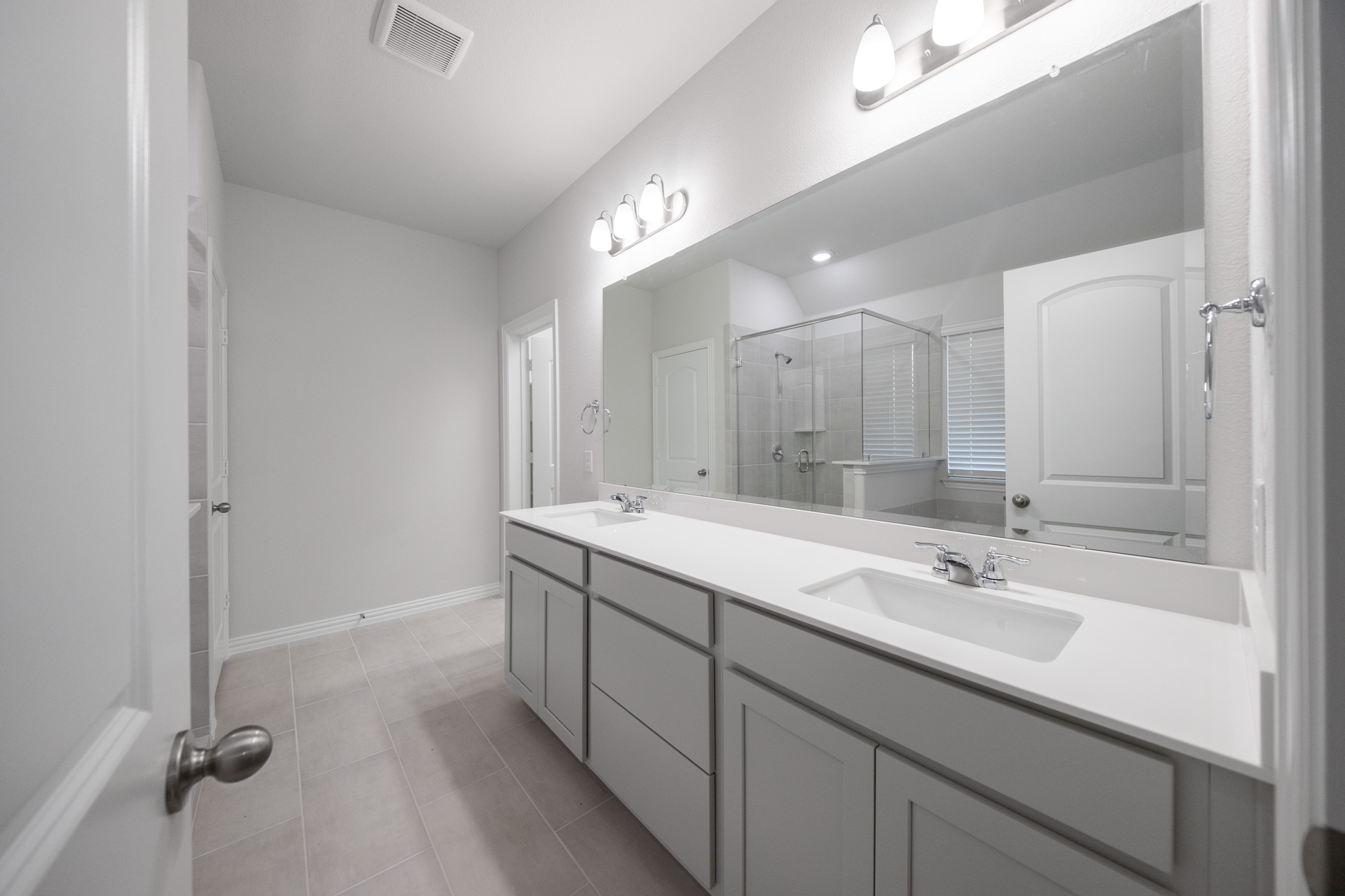 primary bathroom with double sinks and tile flooring