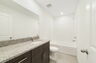 single sink vanity with water closet and large mirror 