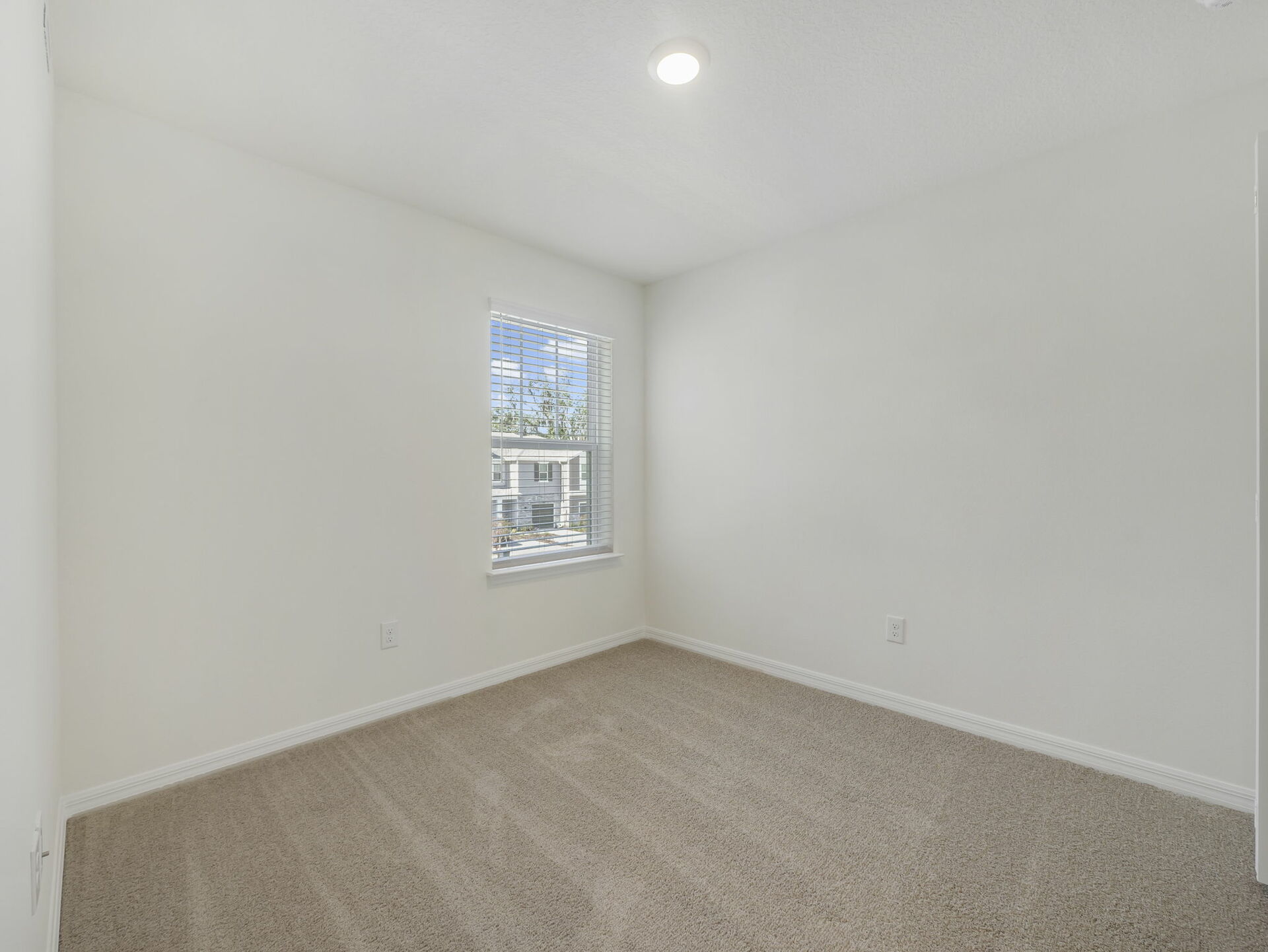 guest bedroom with carpet throughout and large window