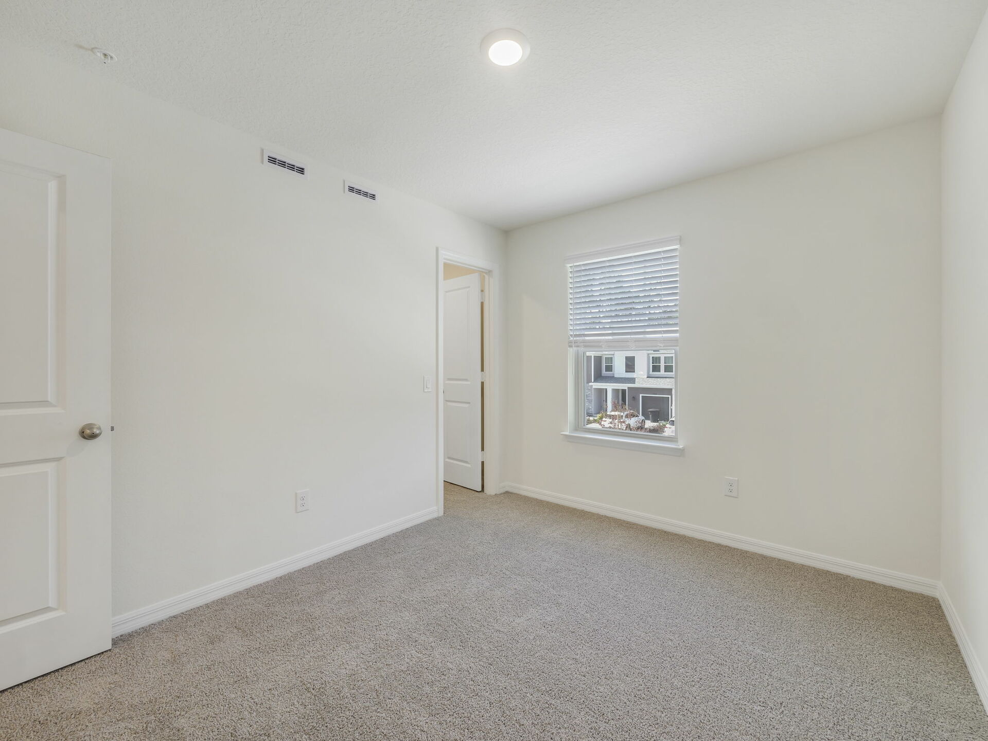 secondary bedroom with carpet and large window
