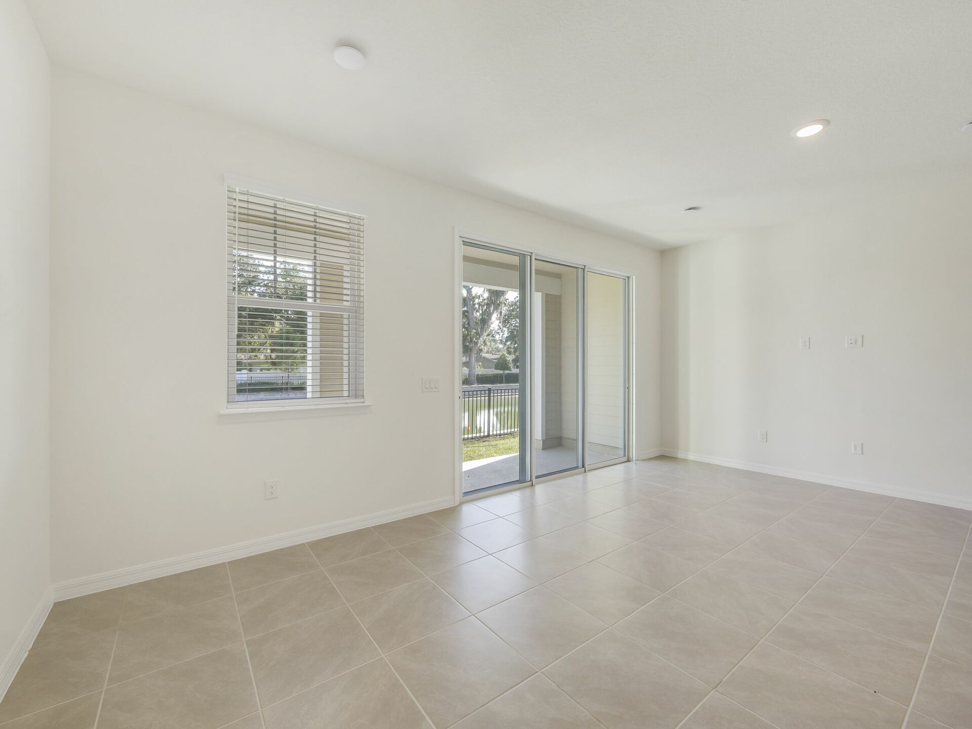 great room with view of kitchen and sliding glass door to covered patio