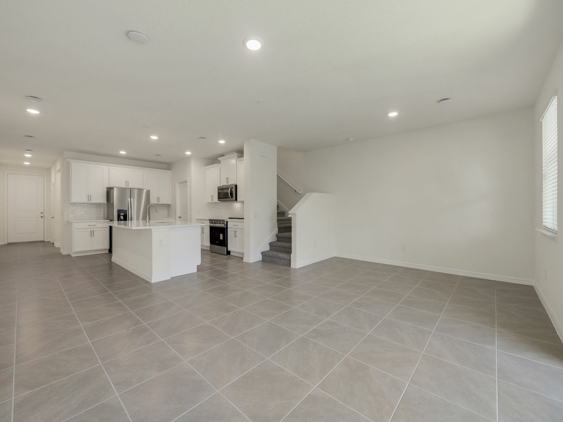 great room with view of kitchen and sliding glass door to covered patio