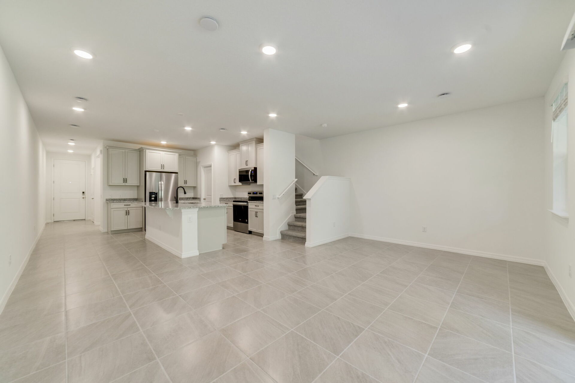 great room with view of the kitchen and sliding glass door to covered lanai