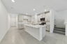 center island kitchen with view of great room and access to the stairs