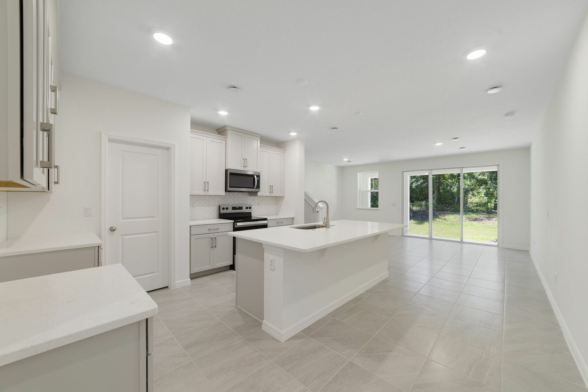 center island kitchen with view of great room and access to the stairs