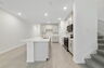 center island kitchen with view of great room and access to the stairs