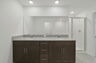 dual sink vanity with water closet, shower, and tub